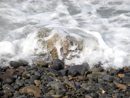 Background from beach pebbles and sea foam.の写真素材
