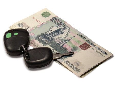Car key and stack of Russian thousand rubles banknotes isolated on white background.の写真素材