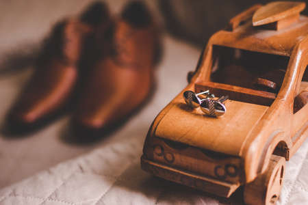 Cuff links and shoes on a brown backgroundの写真素材