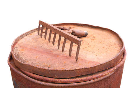 Rusty rake on rusty barrel garden tools old on white backgroundの写真素材