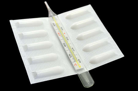 Medical suppository and thermometer on black backgroundの写真素材