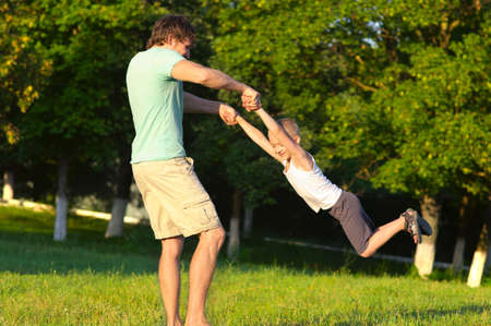 Family Father Man and Son Boy playing Outdoor park flying round Happiness emotion with summer nature on backgroundの写真素材