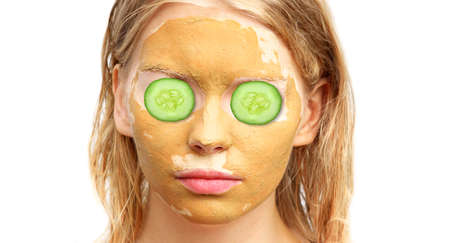 Spa Woman Face with facial Clay Mask Organic Beauty treatments Skin Care with cucumber slices on eyes isolated on white backgroundの写真素材