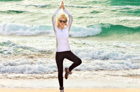Young Woman Training Sport on Beach Seaside sand with blue Sea on background Fitness and Healthy Lifestyle conceptの写真素材