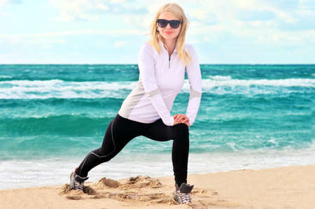Young Woman Training Sport on Beach Seaside sand with blue Sea on background Fitness and Healthy Lifestyle conceptの写真素材
