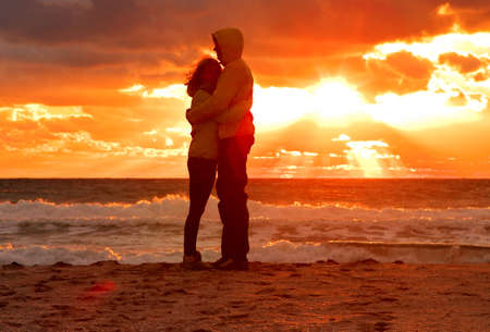 Couple Man and Woman Hugging in Love staying on Beach seaside with Sunset scenery People Romantic relationship and Friendship conceptの写真素材