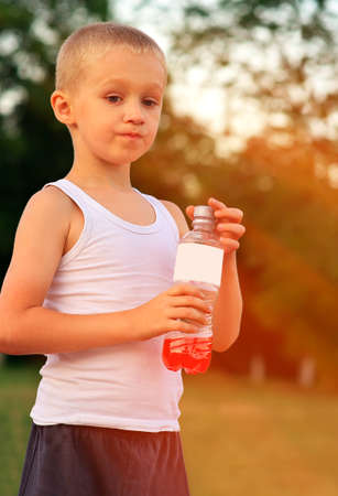 Boy Child caucasian drinking Juice Beverage plastic bottle hot weather summer day outdoorの写真素材