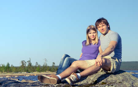Happy Couple Man and Woman Caucasian Family sitting and hugging Outdoor vacations traveling lake and blue sky on backgroundの写真素材