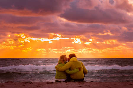 Couple Man and Woman in Love kissing and hugging on Beach seaside with Beautiful Sunset sky scenery People Romantic relationship conceptの写真素材