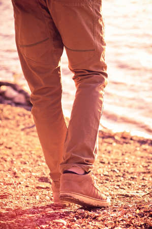 Foot man walking outdoor on beach trendy style melancholy conceptの写真素材