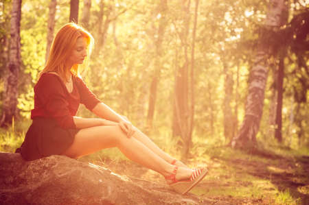 Young Woman relaxing outdoor in sunny forest alone Lifestyle Summer vacations concept trendy retro colorsの写真素材