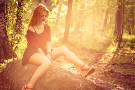 Young Woman relaxing outdoor in sunny forest alone Lifestyle Summer vacations concept trendy retro colorsの写真素材