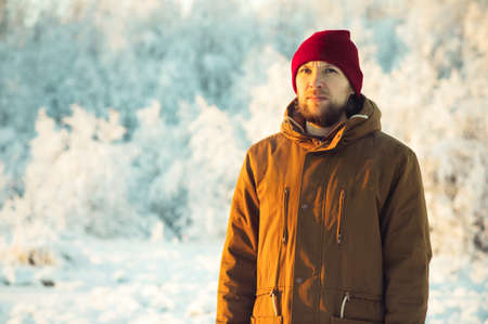 Young Man wearing winter hat fashion clothing outdoor winter snow nature on background Travel Lifestyle and melancholy emotions concept film effects colorsの写真素材