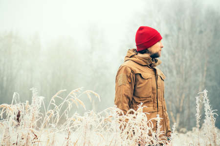 Young Man wearing winter hat clothing outdoor with foggy forest nature on background Travel Lifestyle and melancholy emotions concept film effects colorsの写真素材