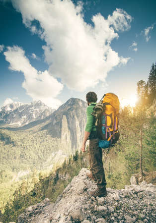 Young Man with backpack relaxing outdoor Travel Lifestyle hiking concept with rocky mountains on background Summer vacationsの写真素材
