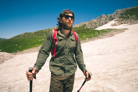 Young Man with backpack hiking outdoor Travel Lifestyle concept mountains on background Summer vacationsの写真素材