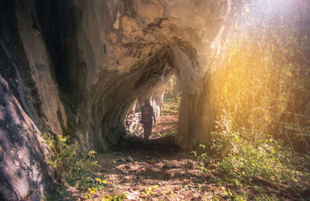 Woman Traveler hiking in a rocky tunnel Travel Lifestyle concept mountains on background Summer journey vacations outdoorの写真素材