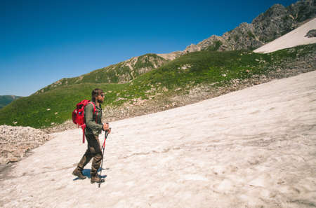 Traveler Man with backpack mountaineering glacier outdoor Travel Lifestyle concept mountains on backgroundの写真素材