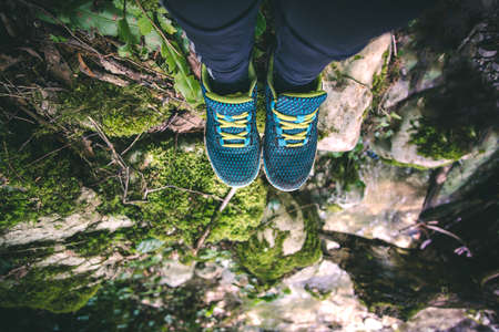 Feet Woman running shoes relaxing in forest Travel Lifestyle concept stones on background Summer vacationsの写真素材