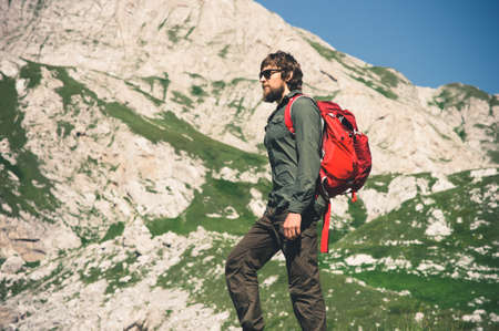 Traveler Man bearded with backpack mountaineering Travel Lifestyle concept mountains on background Summer journey vacations outdoorの写真素材