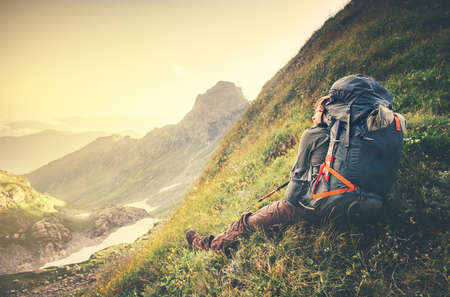 Man Traveler with big backpack relaxing Travel Lifestyle concept sunset mountains landscape on background Summer vacations adventure outdoorの写真素材
