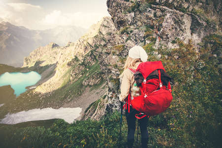 Woman Traveler with red backpack mountaineering Travel Lifestyle concept lake and mountains landscape on background Summer vacations adventure outdoorの写真素材