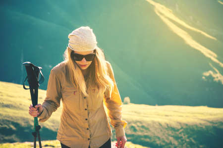 Young Woman hiking with trekking poles Travel Lifestyle concept Summer journey vacations outdoor mountains on backgroundの写真素材
