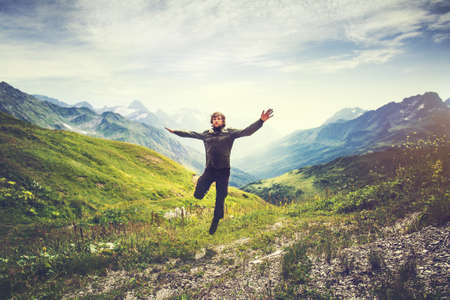 Traveler Man jumping with mountains landscape on background Lifestyle Travel happy emotions concept outdoorの写真素材