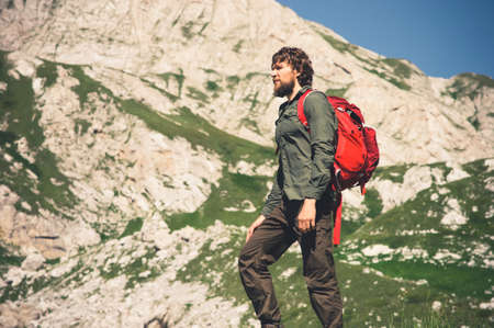 Traveler Man bearded with backpack mountaineering Travel Lifestyle concept mountains on background Summer journey vacations outdoorの写真素材
