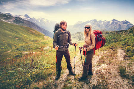 Happy Couple Man and Woman Travelers with backpacks hiking Travel Lifestyle and family love concept mountains landscape on backgroundの写真素材