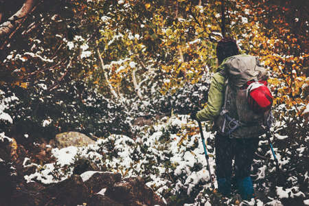 Traveler with backpack hiking in forest Travel Lifestyle adventure concept autumn nature on background active vacations snow weatherの写真素材