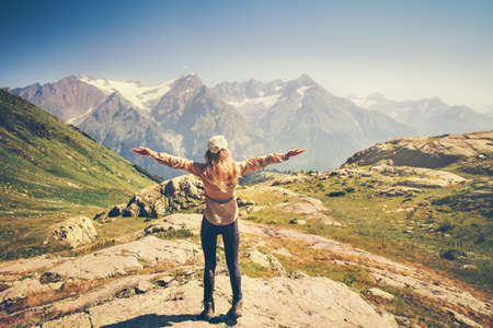 Happy Woman Traveler hands raised hiking with rocky mountains landscape Travel Lifestyle concept adventure summer vacations rear viewの写真素材