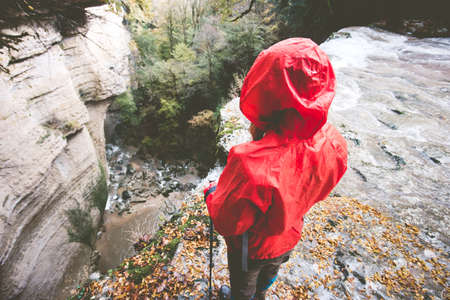 Woman Traveler hiking on rocky cliff Travel Lifestyle adventure concept active vacations into the wild harmony with nature rear viewの写真素材