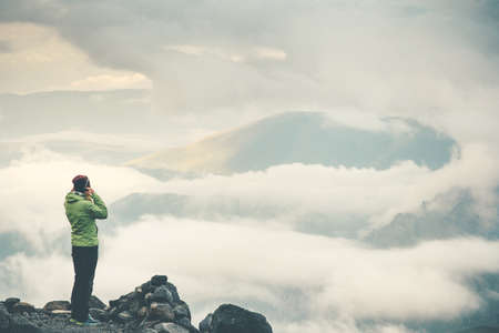 Woman enjoying cloudy foggy mountains landscape on cliff Travel Lifestyle concept adventure vacations outdoorの写真素材