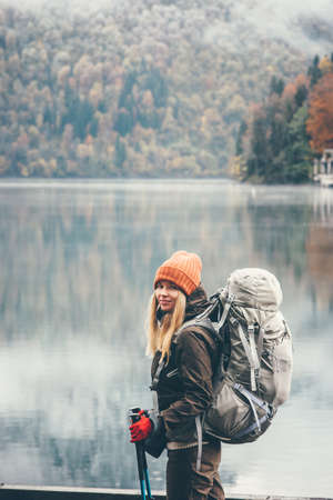 Woman traveling with backpack Lifestyle adventure concept forest and lake on background active vacations into the wildの写真素材