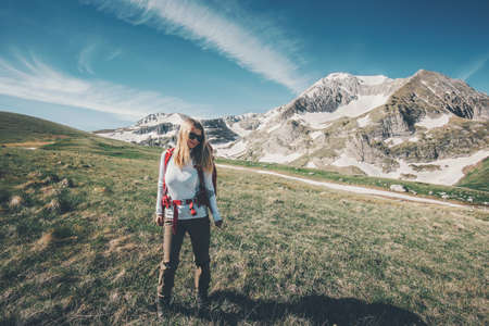 Girl backpacker traveling hiking in mountains Travel Lifestyle success concept adventure active summer vacations outdoor mountaineering sportの写真素材