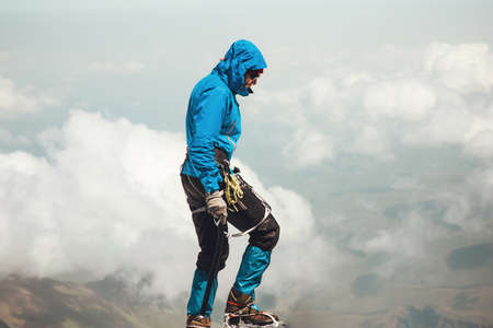 Man climbing to mountain summit Travel Lifestyle concept adventure active vacations outdoor mountaineering sport alpinism equipment ice axe and cramponsの写真素材