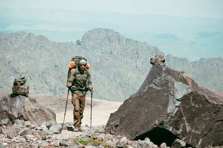 Traveler Man hiking in mountains Travel Lifestyle concept adventure active vacations outdoor mountaineering sport with backpack and trekking polesの写真素材