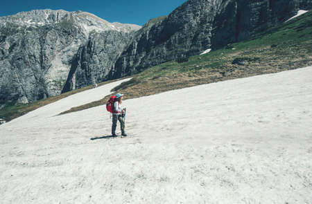 Traveler hiking in mountains with backpack Travel Lifestyle concept adventure active summer vacations outdoor into the wildの写真素材