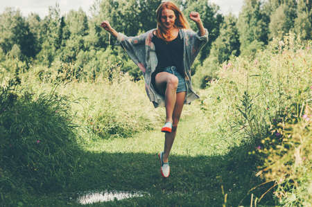 Young Woman happy jumping up summer vacations forest landscape on background Lifestyle Travel fun emotions success concept outdoorの写真素材