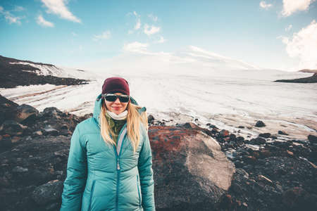 Woman traveler happy smiling with Elbrus mountain on background Travel Lifestyle concept adventure active vacations outdoor mountaineering climbing sport girl wearing down jacket outdoorの写真素材