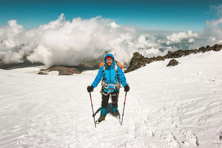 Happy Man alpinist climbing in mountains glacier Travel Lifestyle success concept adventure active vacations outdoor mountaineering sport alpinism equipment clouds on backgroundの写真素材