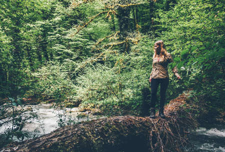 Woman Traveler alone crossing over river on woods outdoor in wild forest Lifestyle Travel extreme survival concept summer adventure vacationsの写真素材