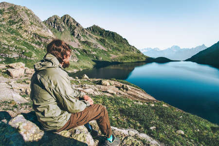 Wanderer Man enjoying lake and mountains view raised hands Travel Lifestyle emotions concept adventure vacations outdoorの写真素材