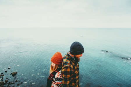 Couple in love Man and Woman back to back standing above sea Traveling together happy emotions Lifestyle concept. Young family romantic vacationsの写真素材