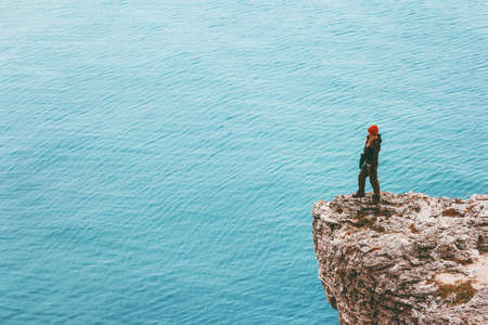 Woman traveler on cliff edge above sea Travel Lifestyle success motivation concept adventure active vacations outdoor harmony with natureの写真素材
