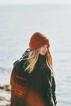 Young Woman walking at winter seaside Travel Fashion Lifestyle concept outdoor. Girl wearing hat and scarf cold weatherの写真素材