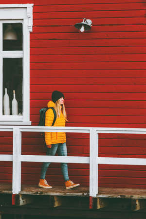 Traveler woman walking in Norway village red house wall on background Travel Lifestyle concept winter vacations outdoorの写真素材