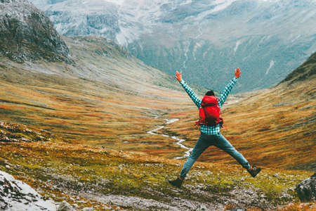 Jumping Man with backpack hands raised mountains landscape on background Lifestyle Travel happy emotions success motivation concept scandinavian vacations outdoor
の写真素材