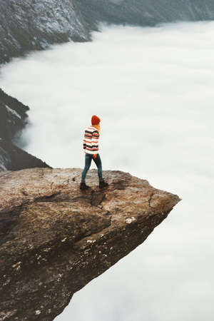 Woman sightseeing Trolltunga rocky cliff   Travel wanderlust Lifestyle adventure concept vacations outdoor above clouds exploring Norway mountainsの写真素材